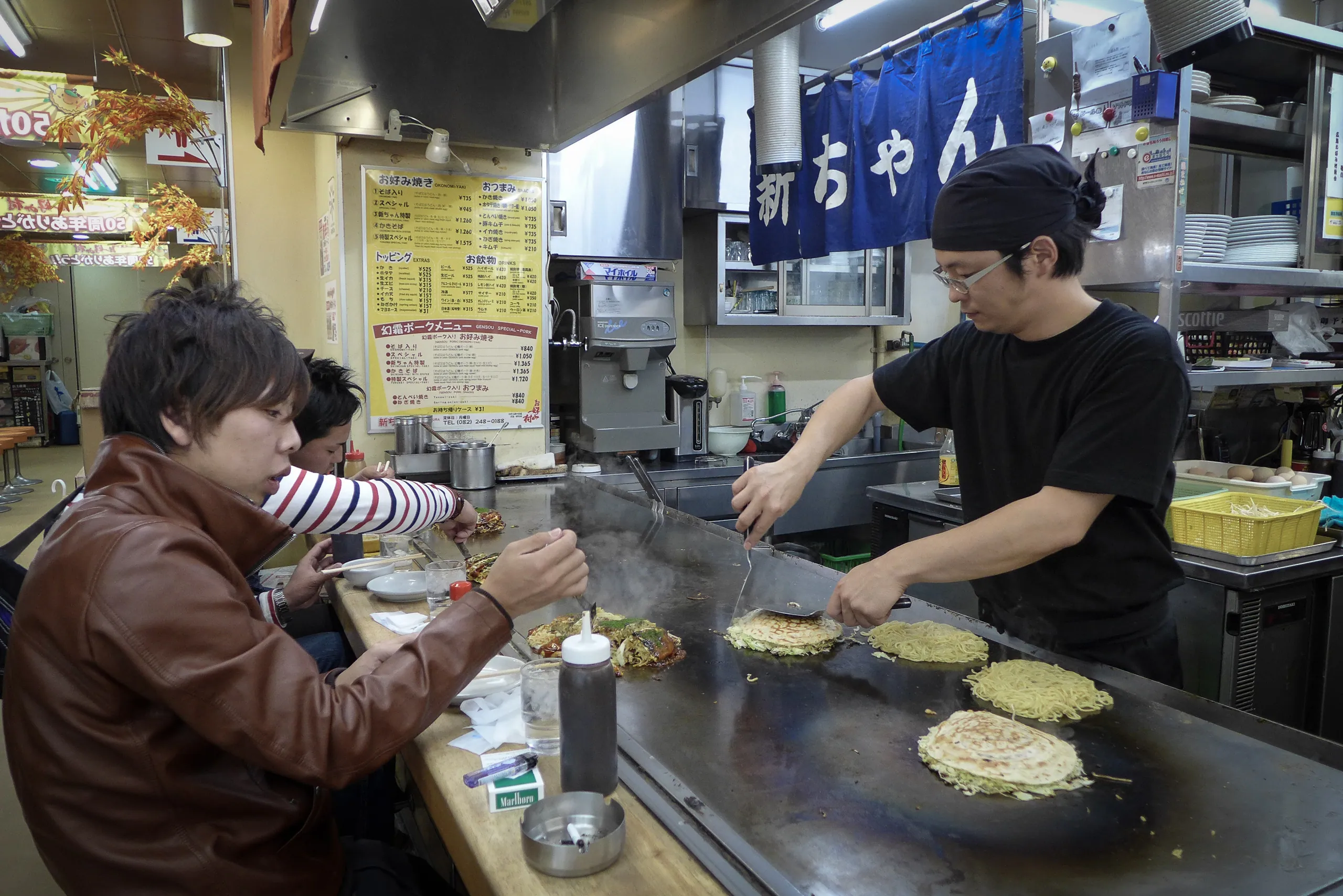 Serving Hiroshima-style Okonomiyaki, Okonomi-mura, Hiroshima
