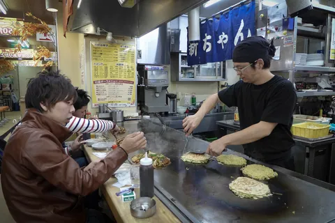 Serving Hiroshima-style Okonomiyaki, Okonomi-mura, Hiroshima
