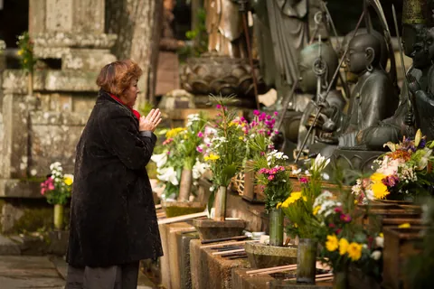 Woman making offering to Jizō Statues, Oku-no-in Cemetery, Koya-san